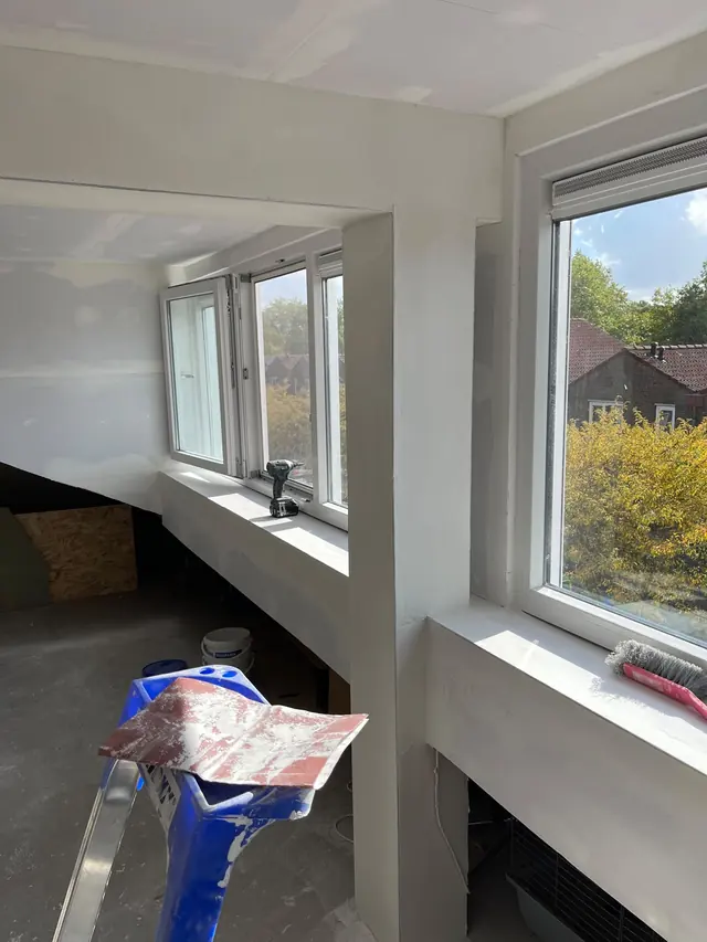 Complete renovatie door GOGU Totaalbouw: lichte ruimte met gladde wanden, brede vensterbanken en nieuwe ramen